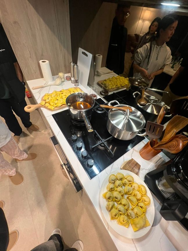 Photo of homemade wontons on large platters next to the stove.